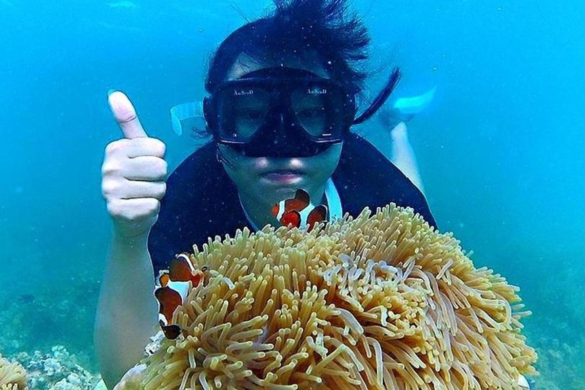 một người đàn ông giơ ngón tay cái lên trên một rạn san hô
