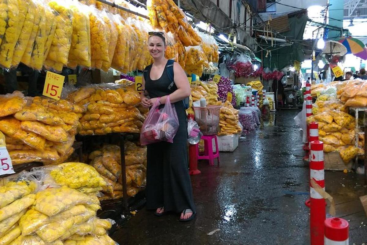 Una mujer parada en un mercado vendiendo comida