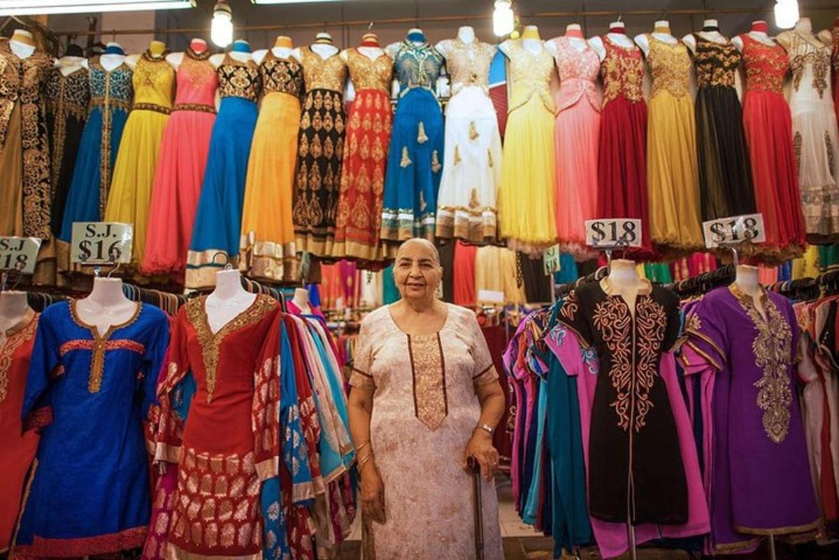uma mulher parada em uma loja com vestidos em exposição