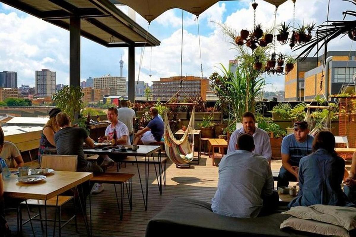 Un grupo de personas sentadas en mesas en un patio.