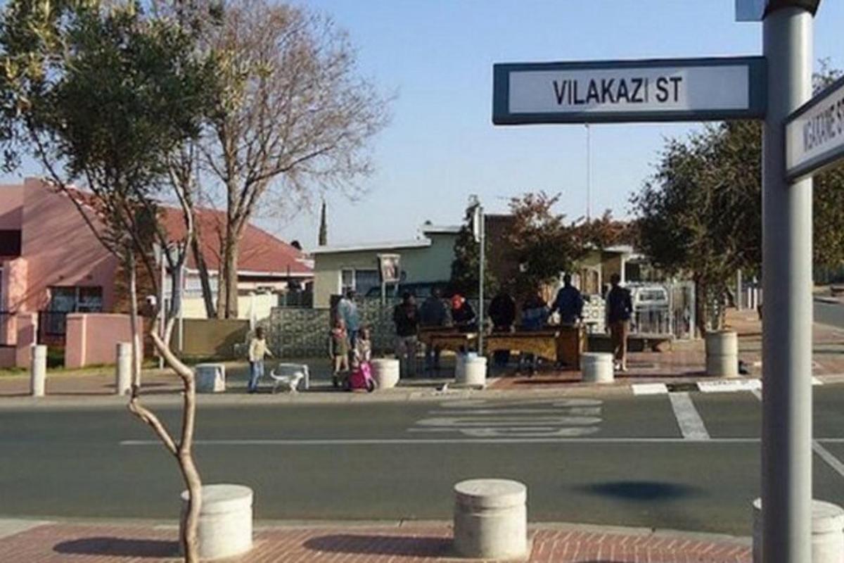 Una señal de calle en una calle con cancha de tenis