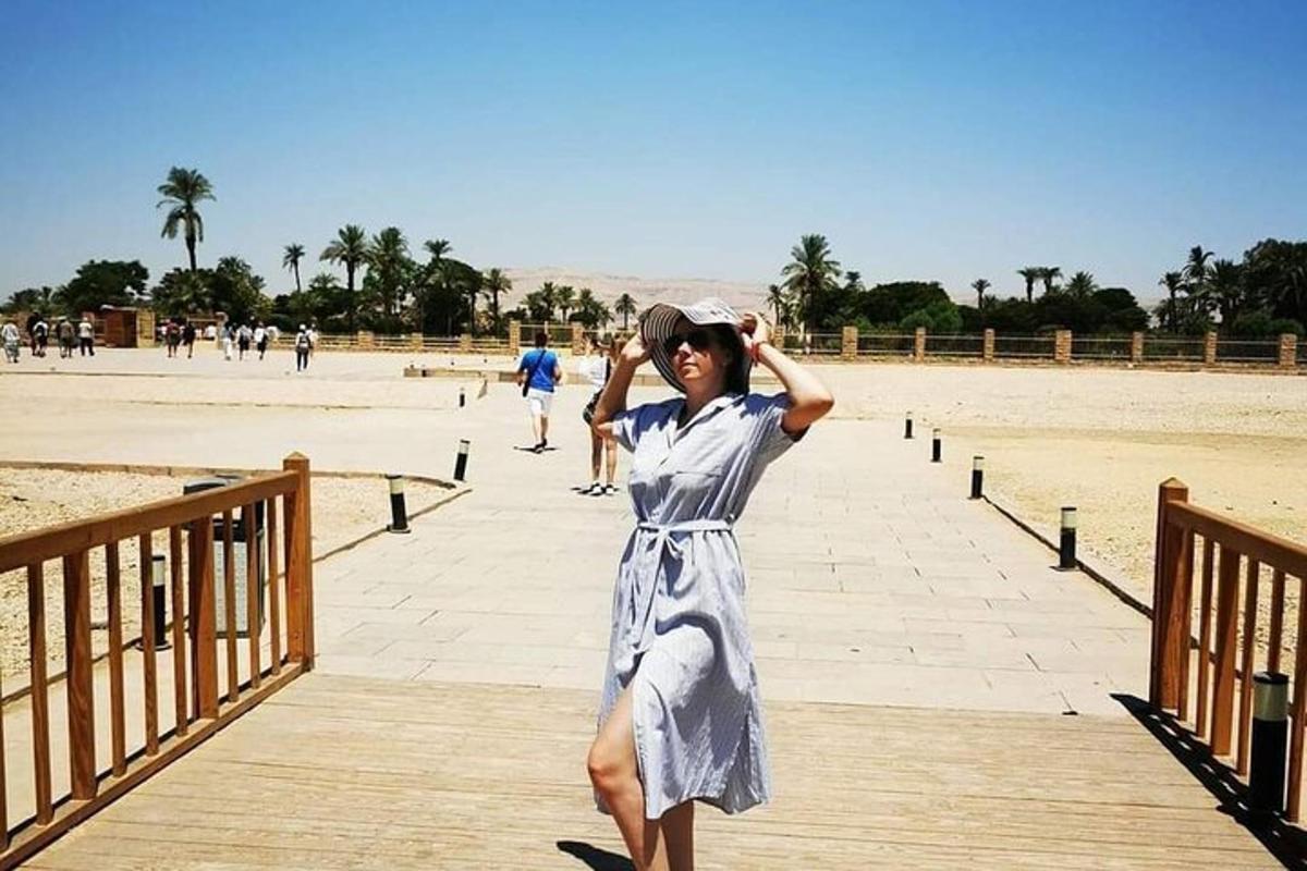 a woman standing on a boardwalk at the beach