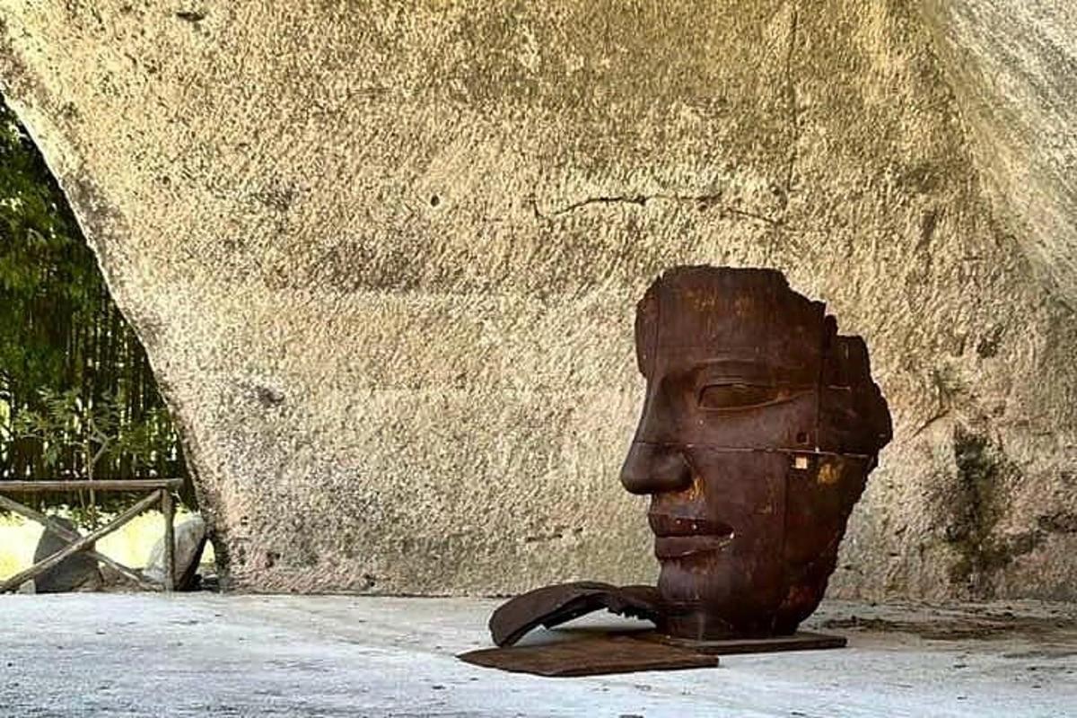 una estatua de una cabeza sentada junto a una pared