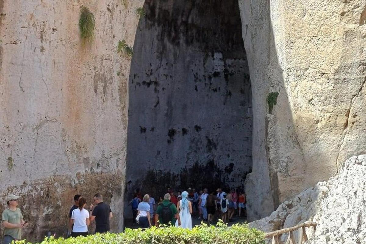 Un grupo de personas caminando por un túnel en una pared.