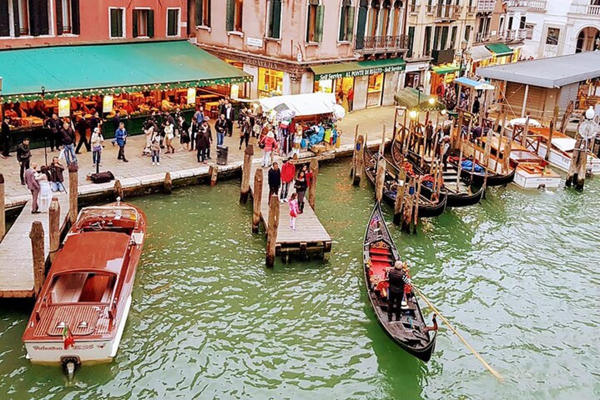 a group of boats docked at a dock in a canal