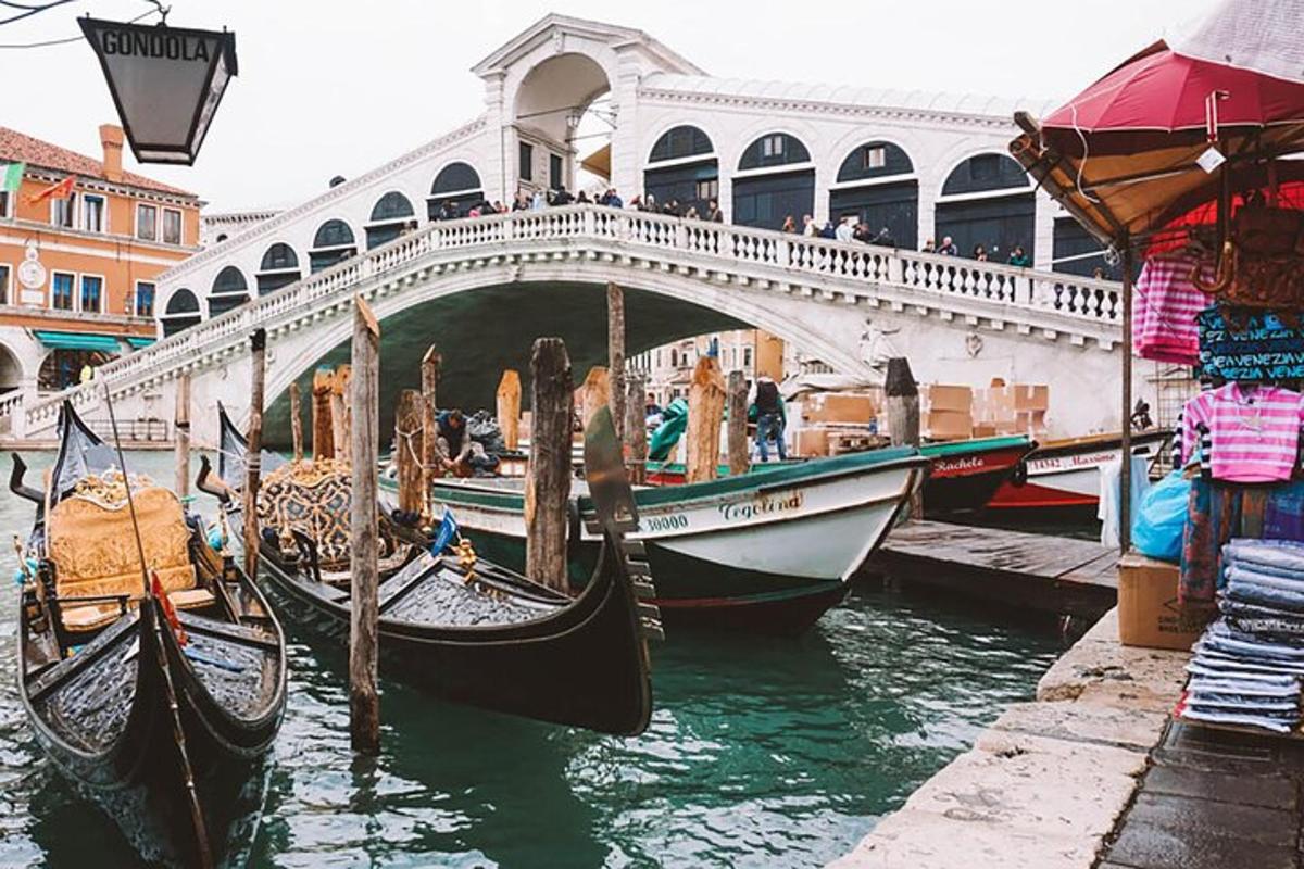 a group of gondolas in the water under a bridge