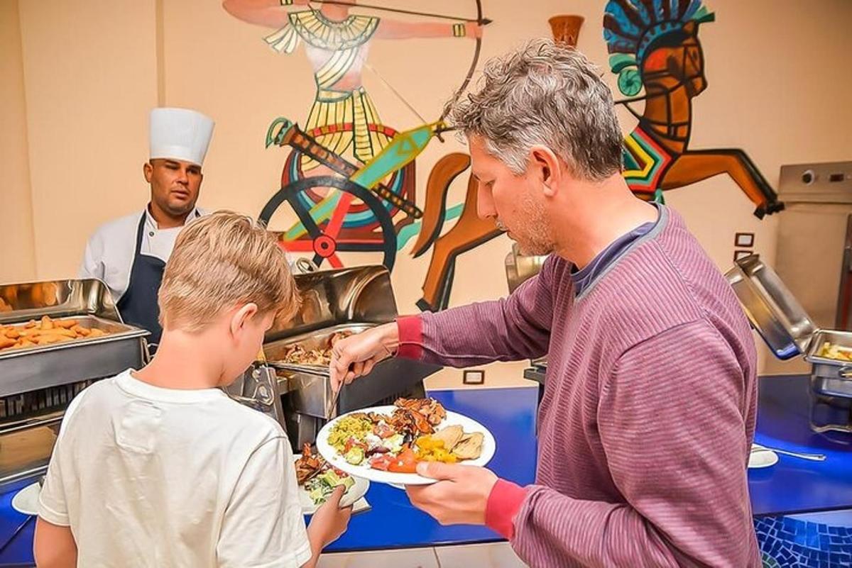 un home donant un plat de menjar a un nen petit