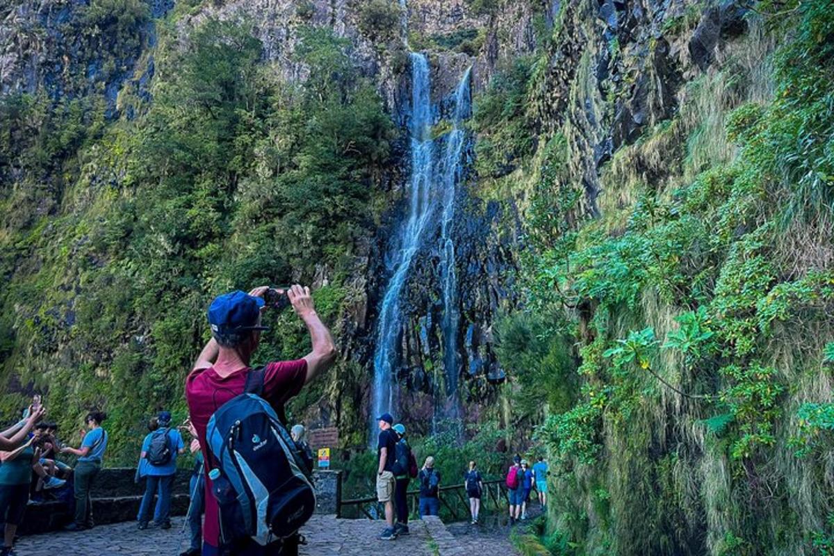 un bărbat care fotografiază o cascadă