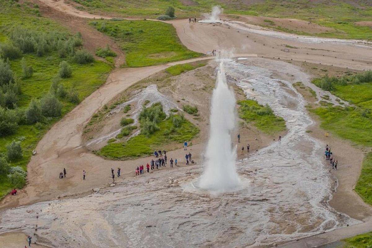 hópur fólks stendur fyrir framan foss