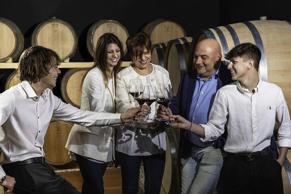 un grup de persones sostenint copes de vi en un celler
