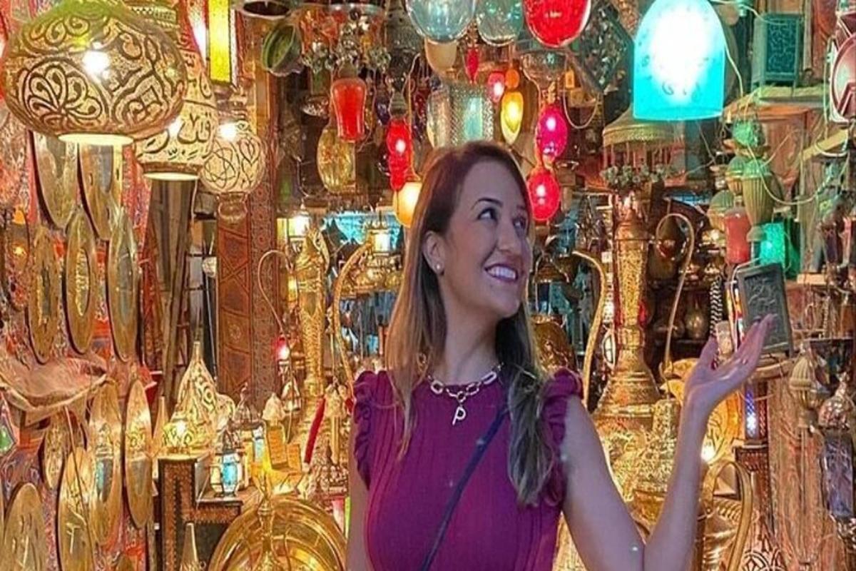 امرأة تحمل هاتفًا محمولًا أمام غرفة بها أضواء