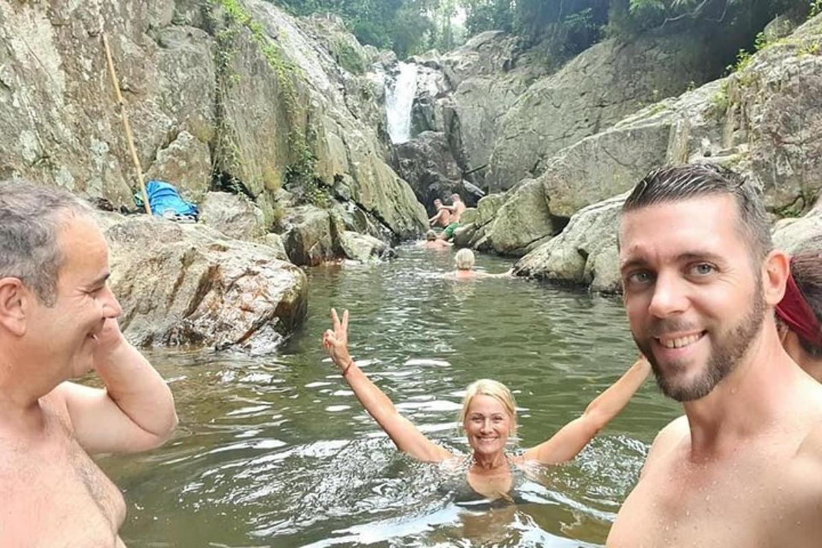 un grup de persones a l'aigua prop d'una cascada