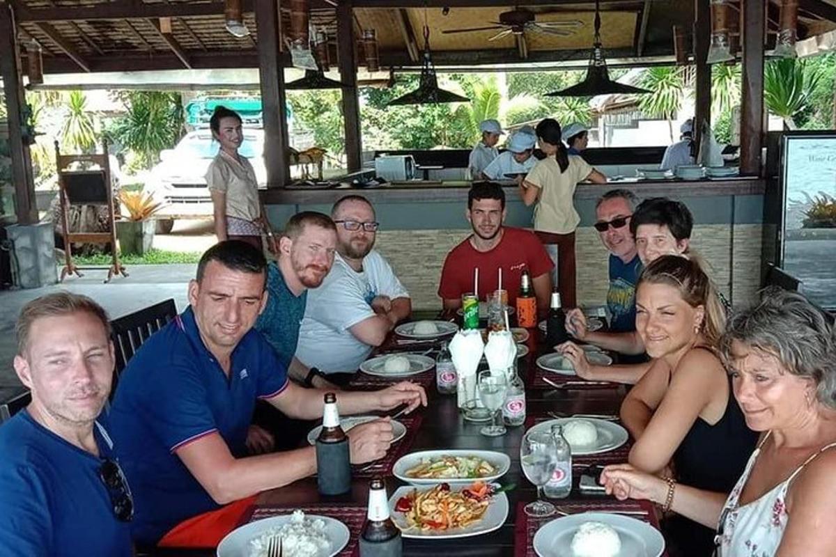 un grup de persones assegudes a una taula menjant