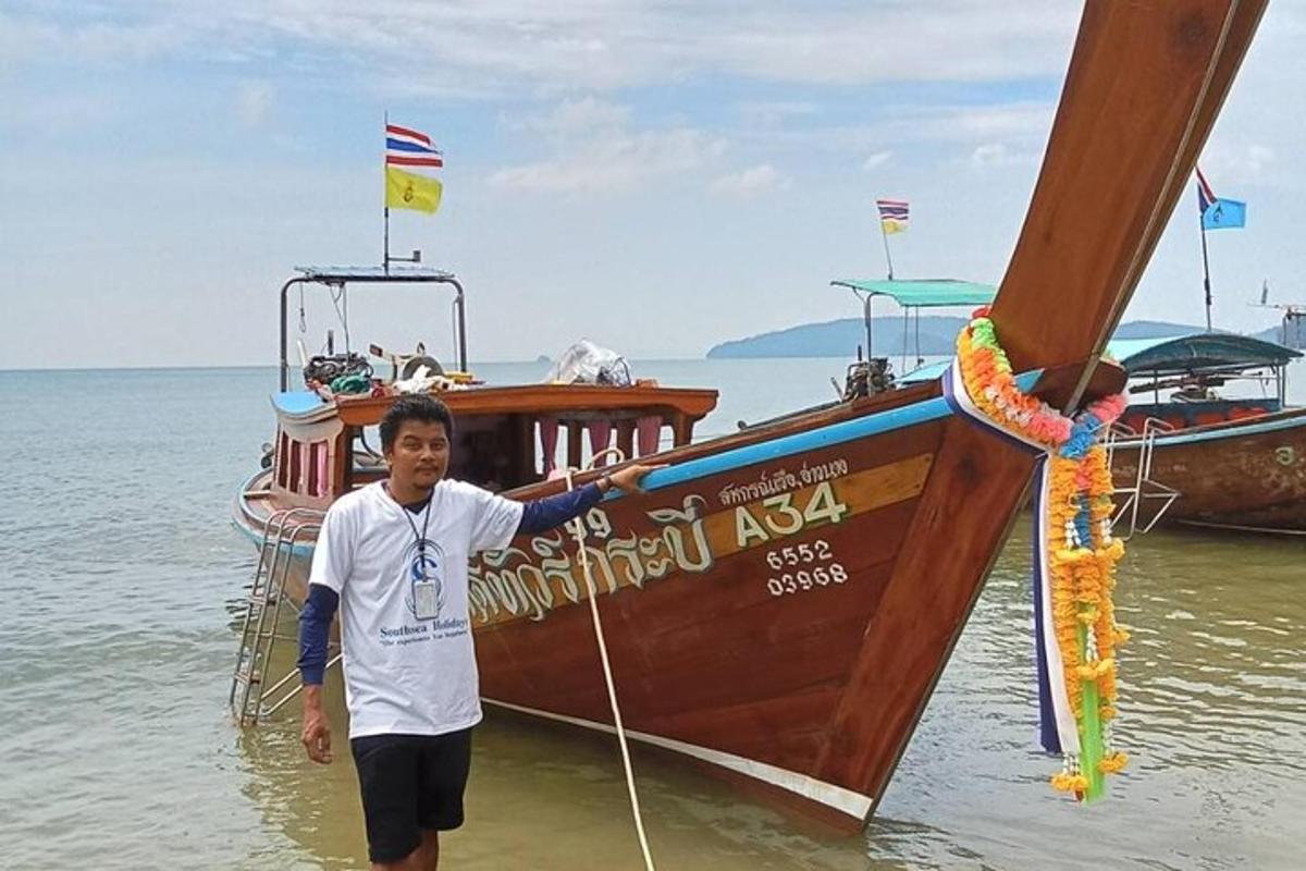 Un hombre parado en el agua junto a un bote.