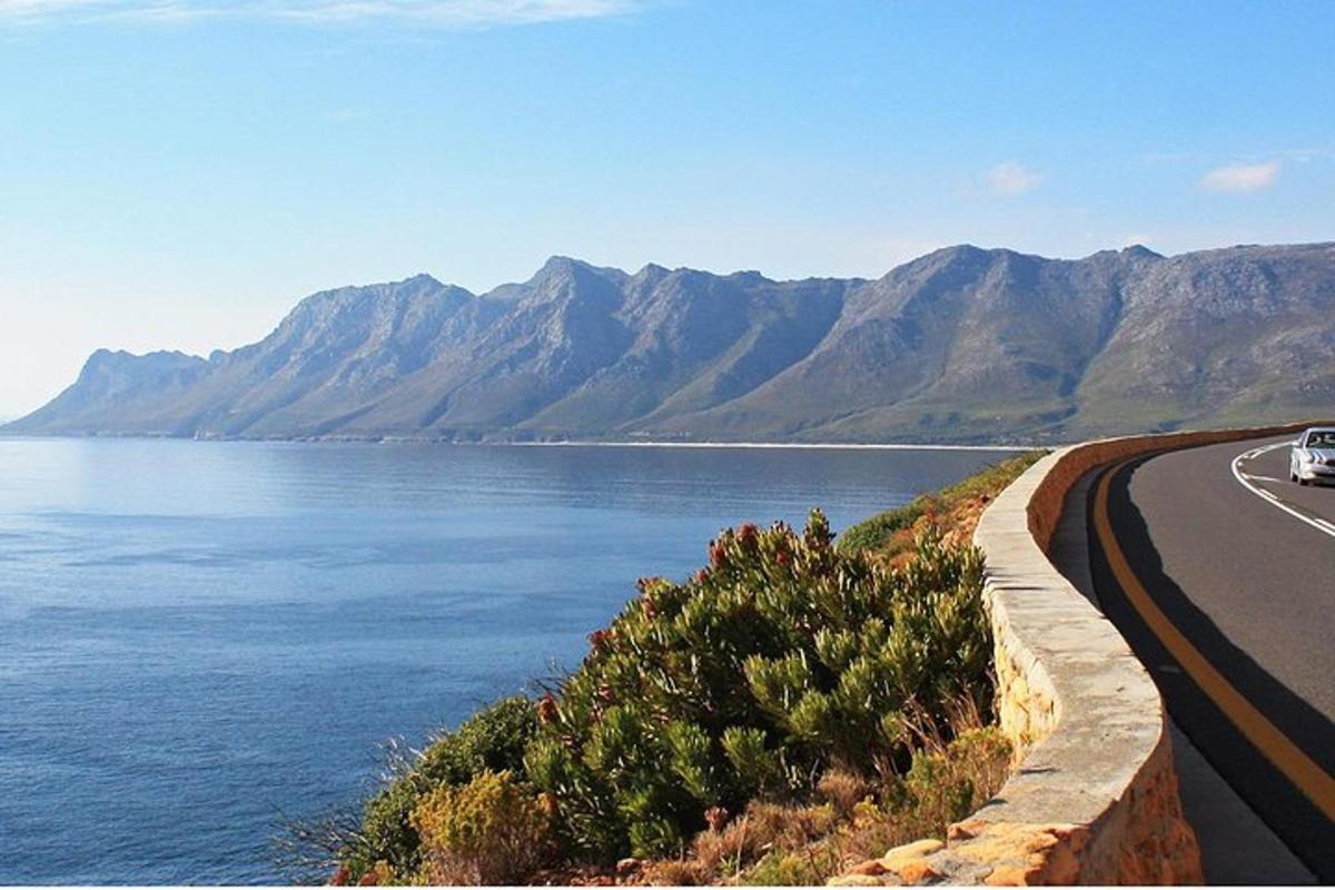 a car driving down a road next to a body of water