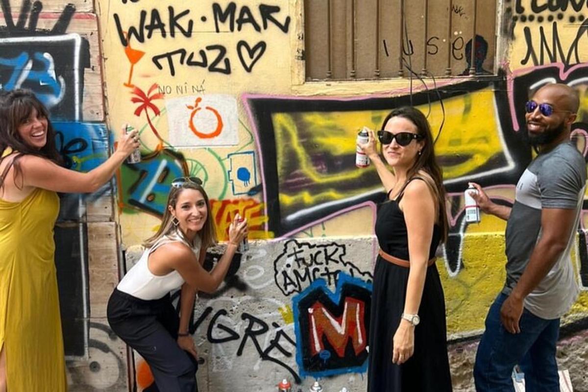 skupina lidí stojících před zdí s graffiti