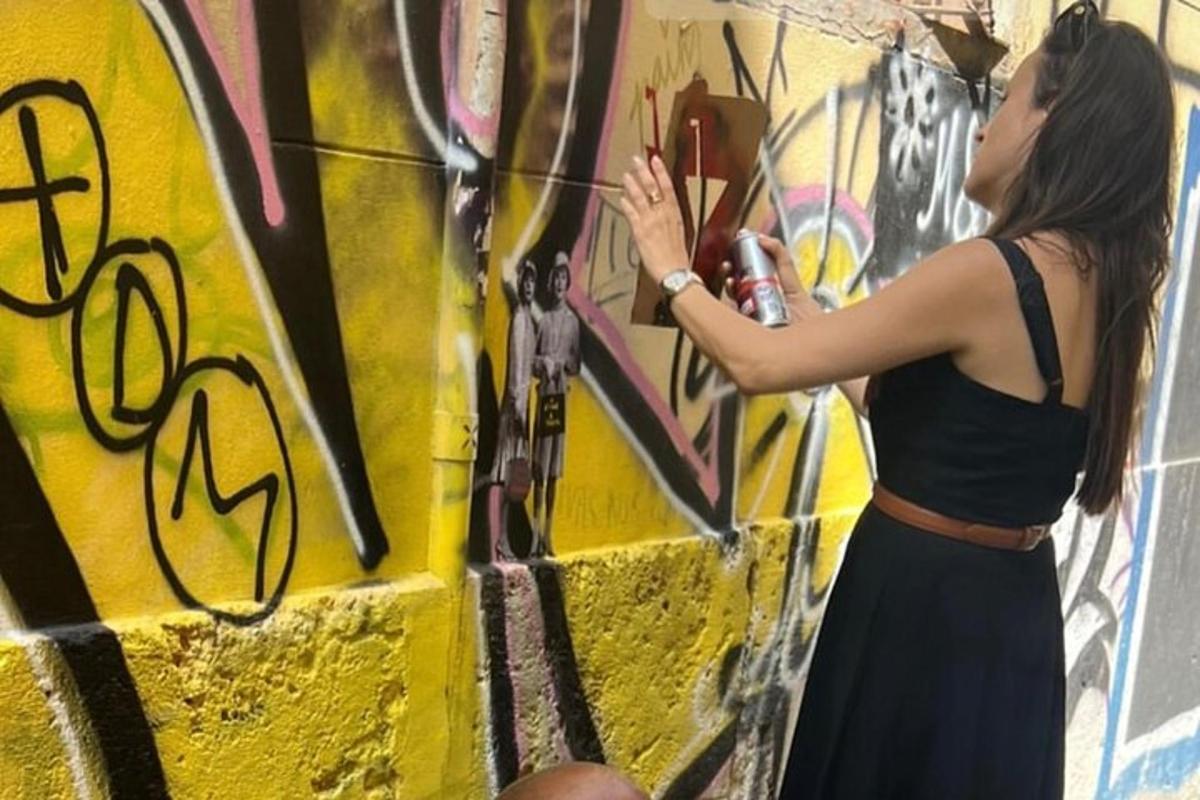 žena maluje zeď graffiti