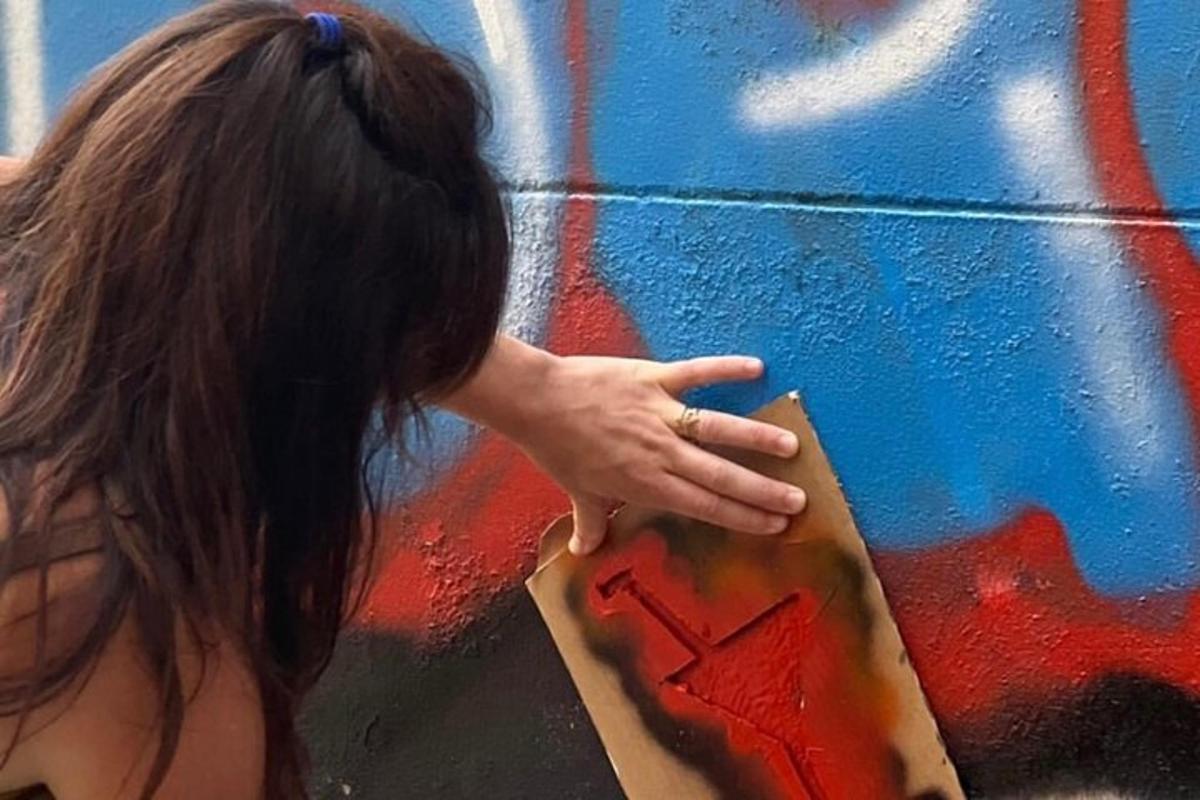 una donna indica un dipinto su un muro