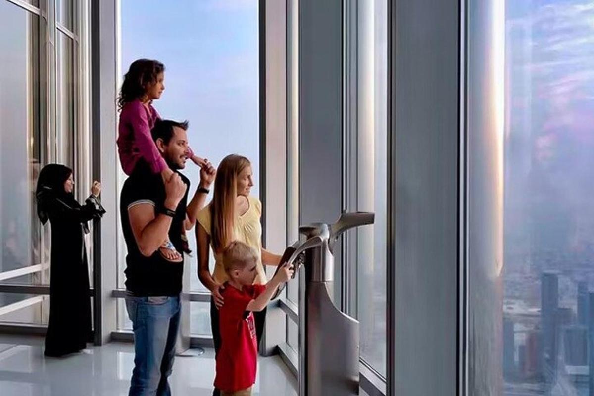 bir gökdelenin penceresinin önünde duran bir aile