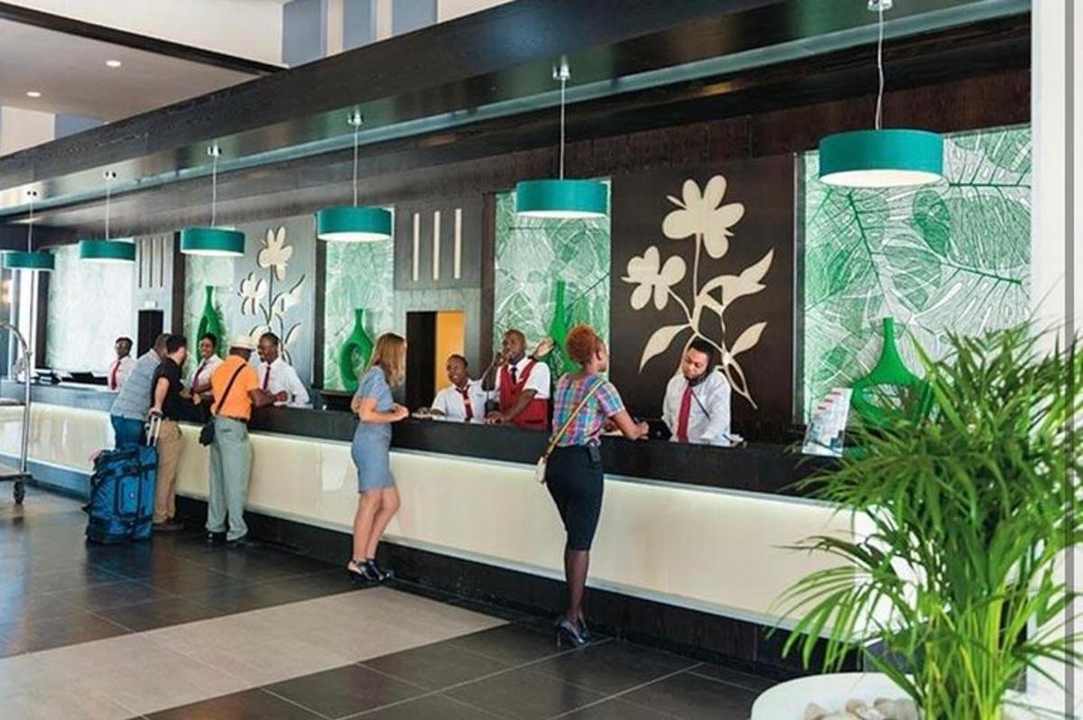 isang grupo ng mga tao na naghihintay sa isang counter sa isang airport