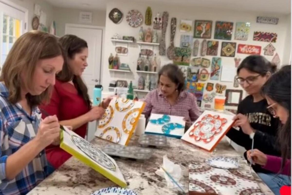 a group of women standing around a table cutting cakes
