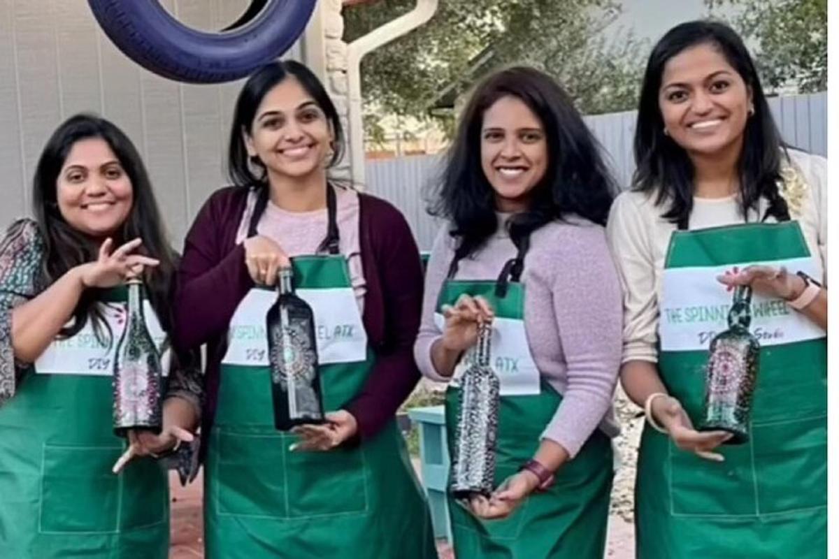 a group of three women holding a bottle of wine