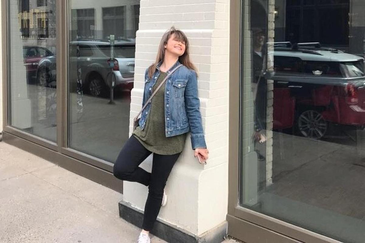 a woman is leaning against a wall in front of a store