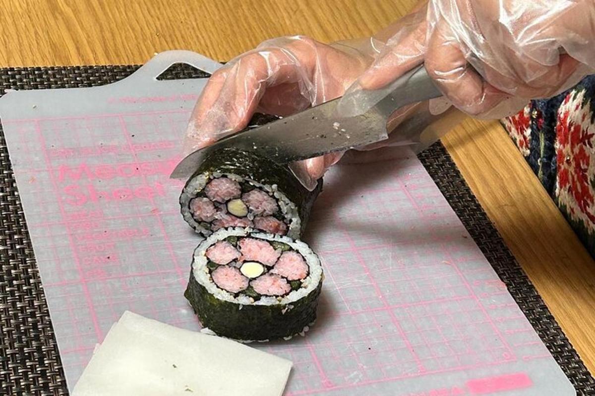 una persona tallant un tros de sushi amb un ganivet
