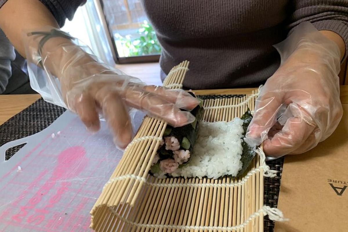 una persona amb guants de plàstic construint una planta de bambú