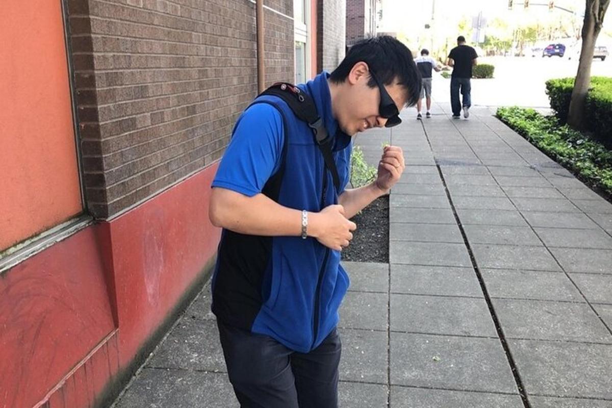 Un hombre parado en una acera comiendo una bebida
