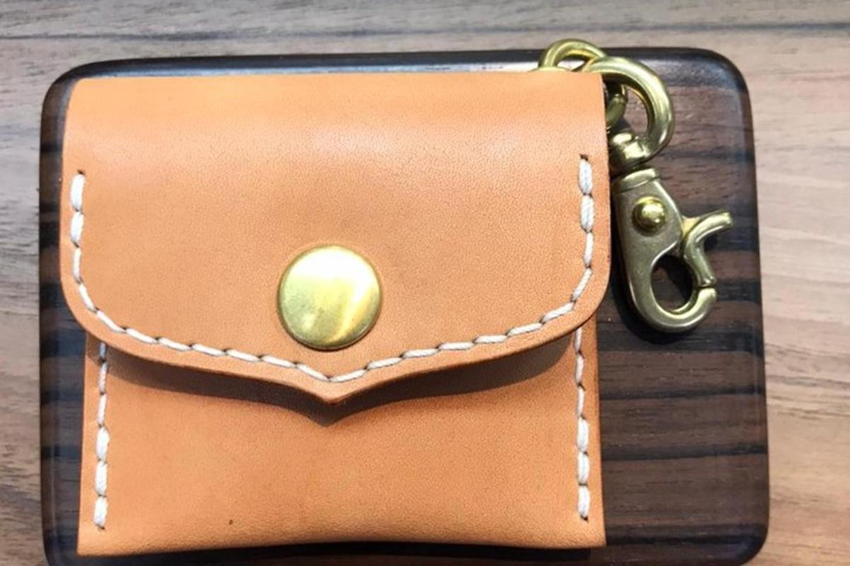 a brown purse with a key on a table