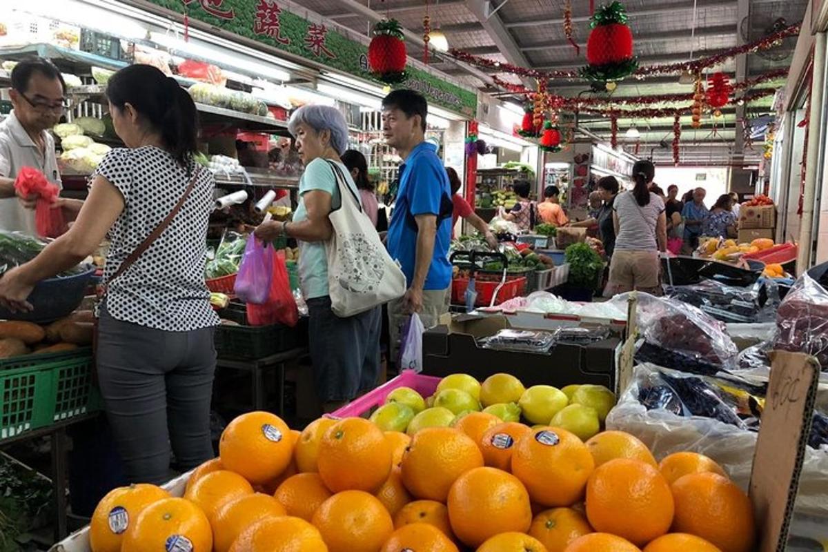 a group of people in a market with fruits and vegetables