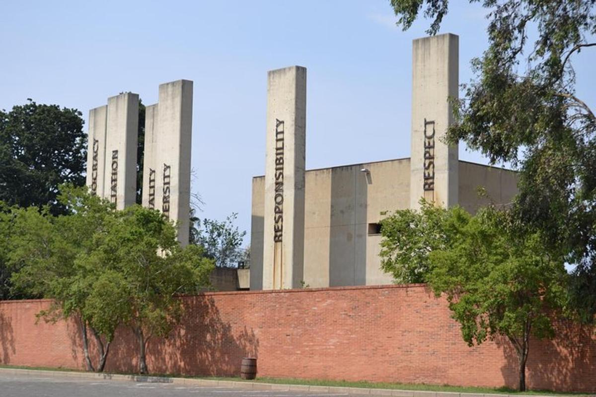 a building with three towers on top of a brick wall