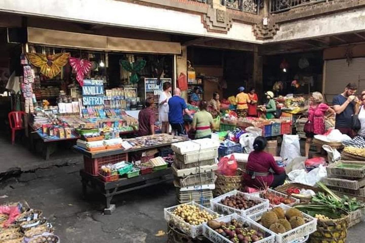 un grup de persones en un mercat amb fruites i verdures