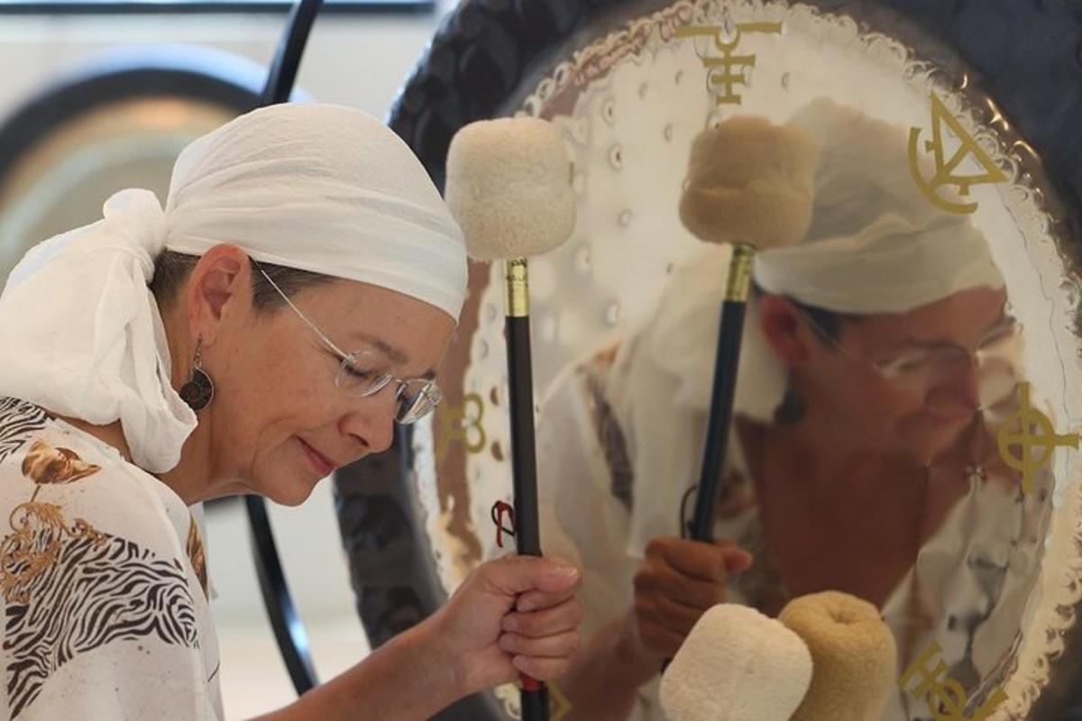 Una mujer sostiene un objeto religioso frente a un espejo.