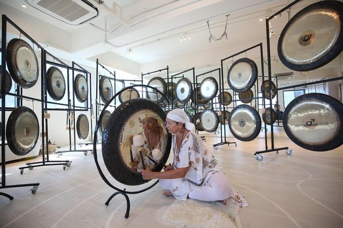Una mujer sentada en el suelo frente a una exhibición de espejos.