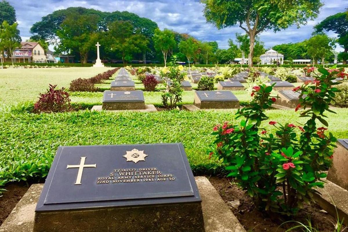 um cemitério com uma cruz e flores em um campo