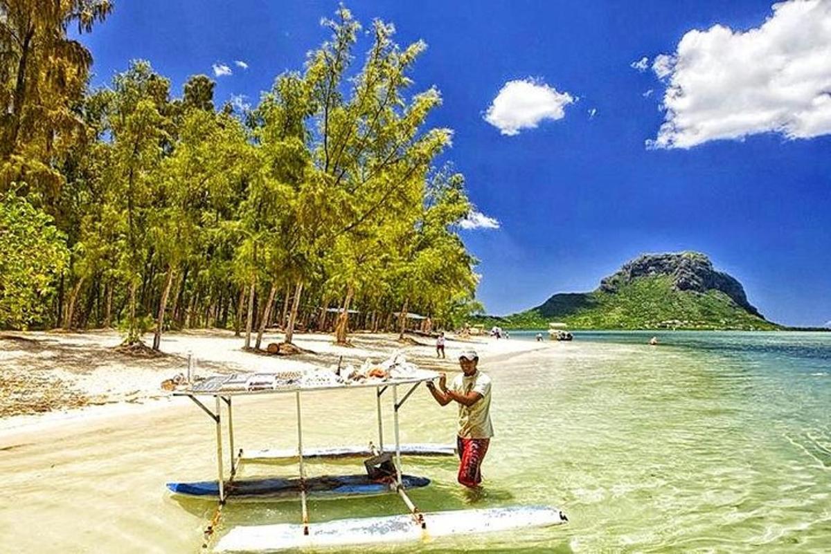 en mann som står på en båt i vannet på en strand