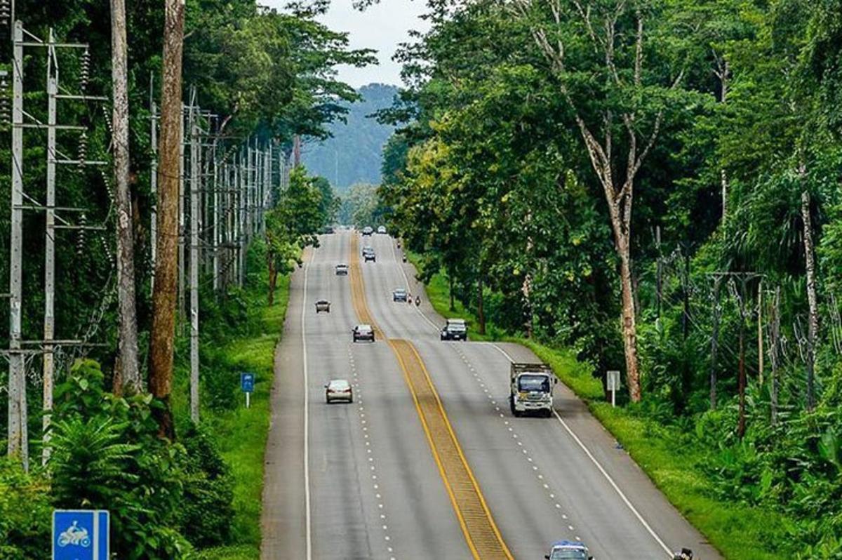 a highway with cars driving down a road with trees