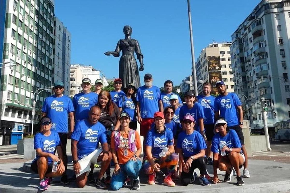 Μια ομάδα ανθρώπων με μπλε πουκάμισα ποζάρουν μπροστά σε ένα άγαλμα