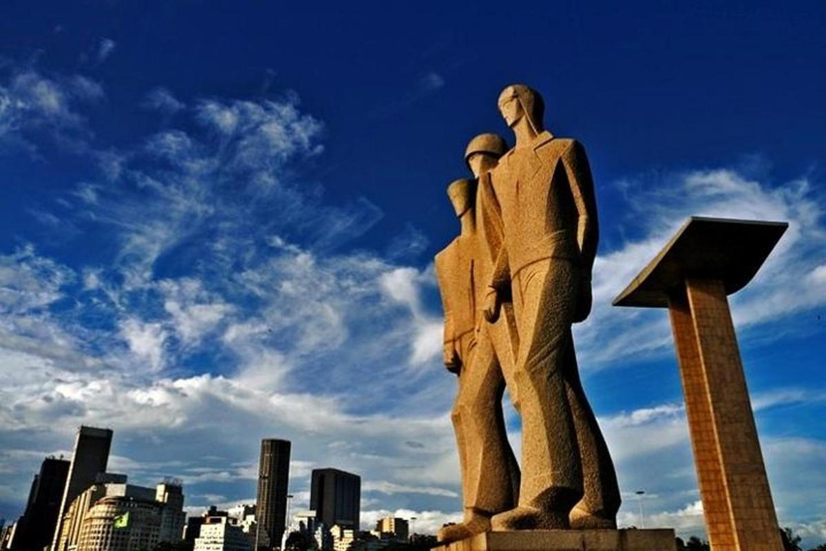 o statuie a doi bărbați cu o săgeată în sus și un oraș