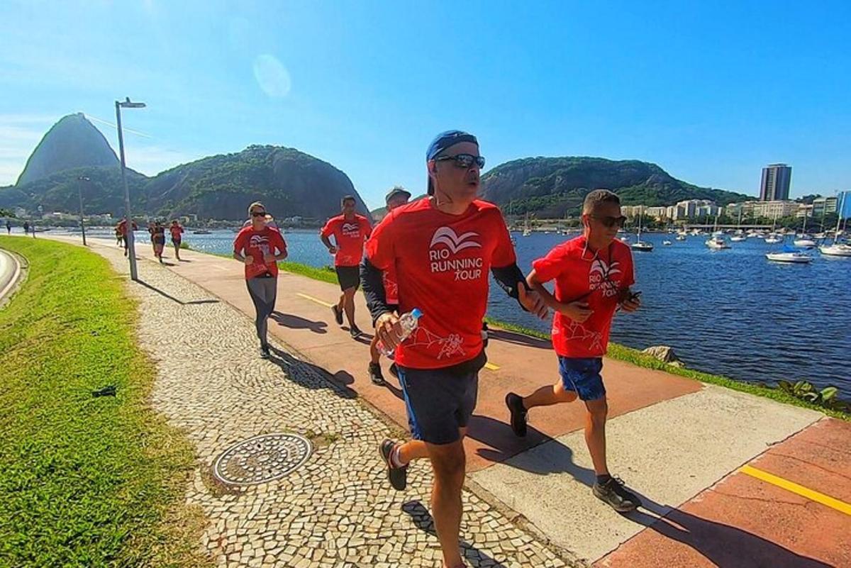 um grupo de pessoas correndo em uma corrida perto da água