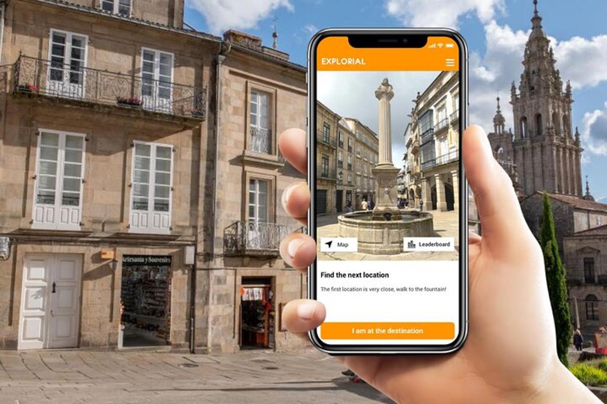 a hand holding up a cell phone to take a picture of a fountain