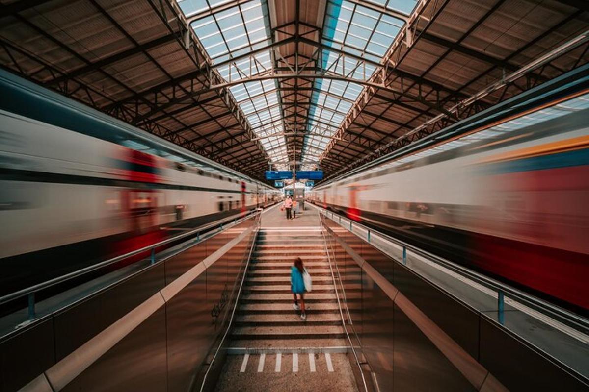 a woman walking in a subway station with two trains