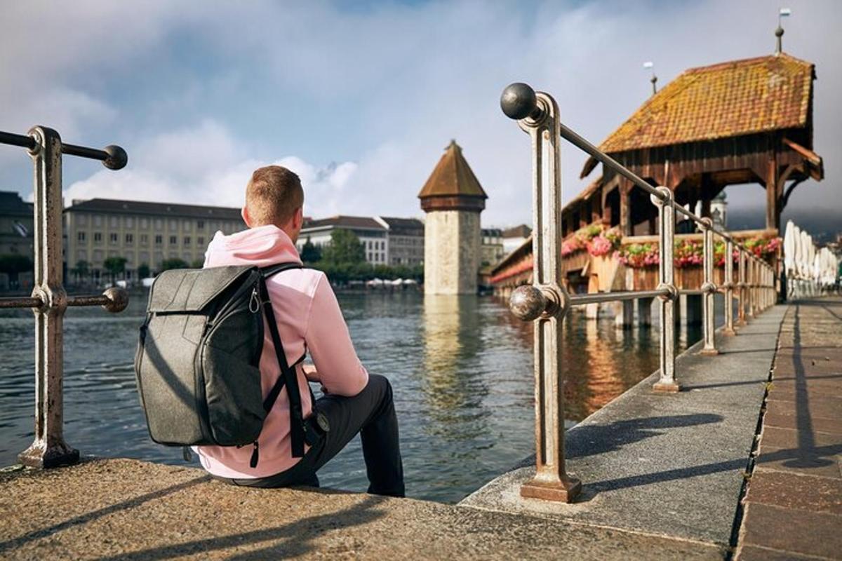 um homem com uma mochila sentado perto da água