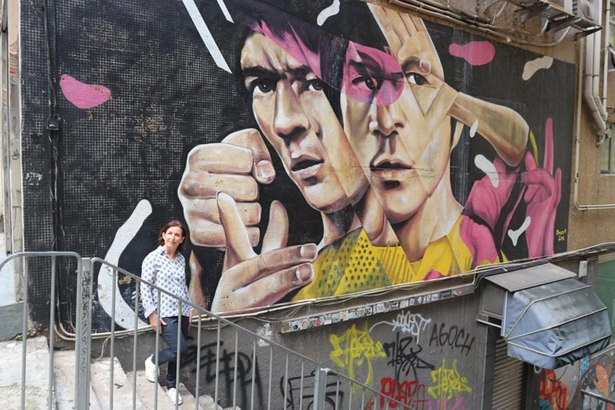 o femeie care stă în fața unui perete cu o pictură murală