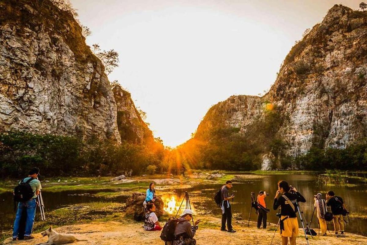 Un grupo de personas de pie alrededor de un fuego en un río.
