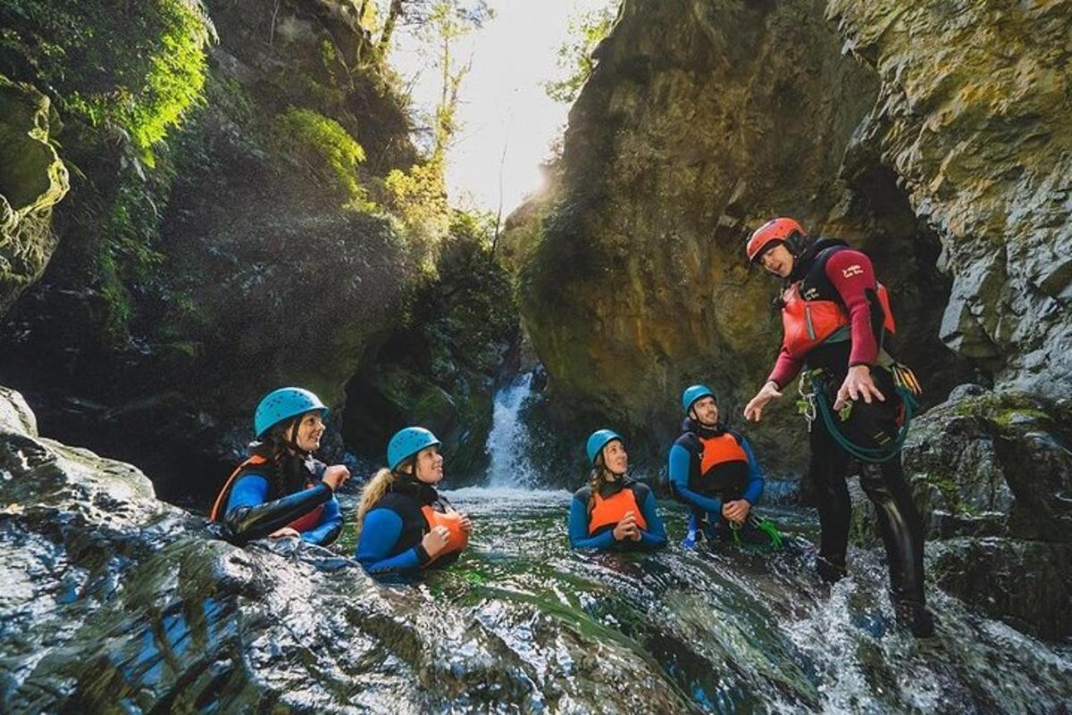 sekelompok orang duduk di atas batu di air terjun