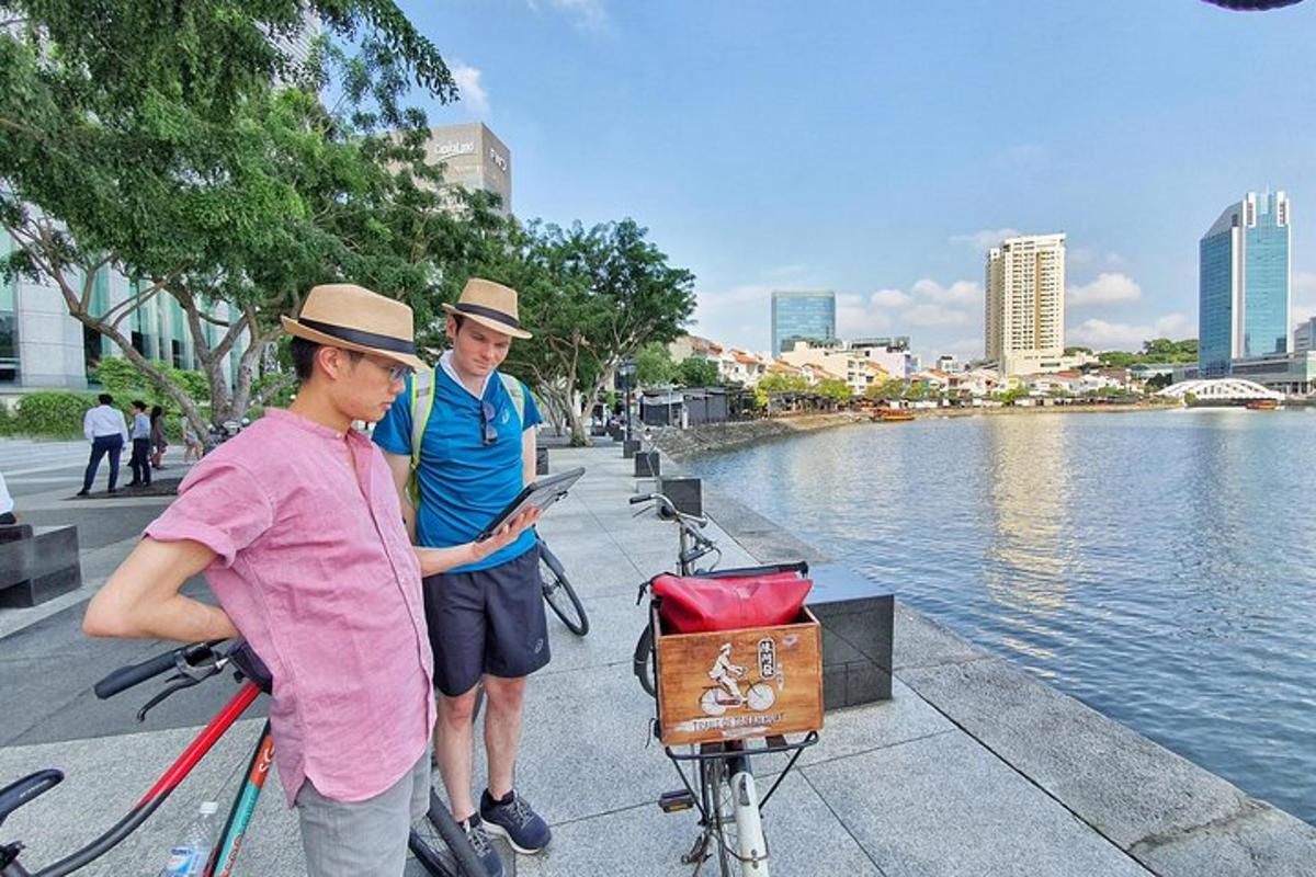 two men standing next to a river with a bike