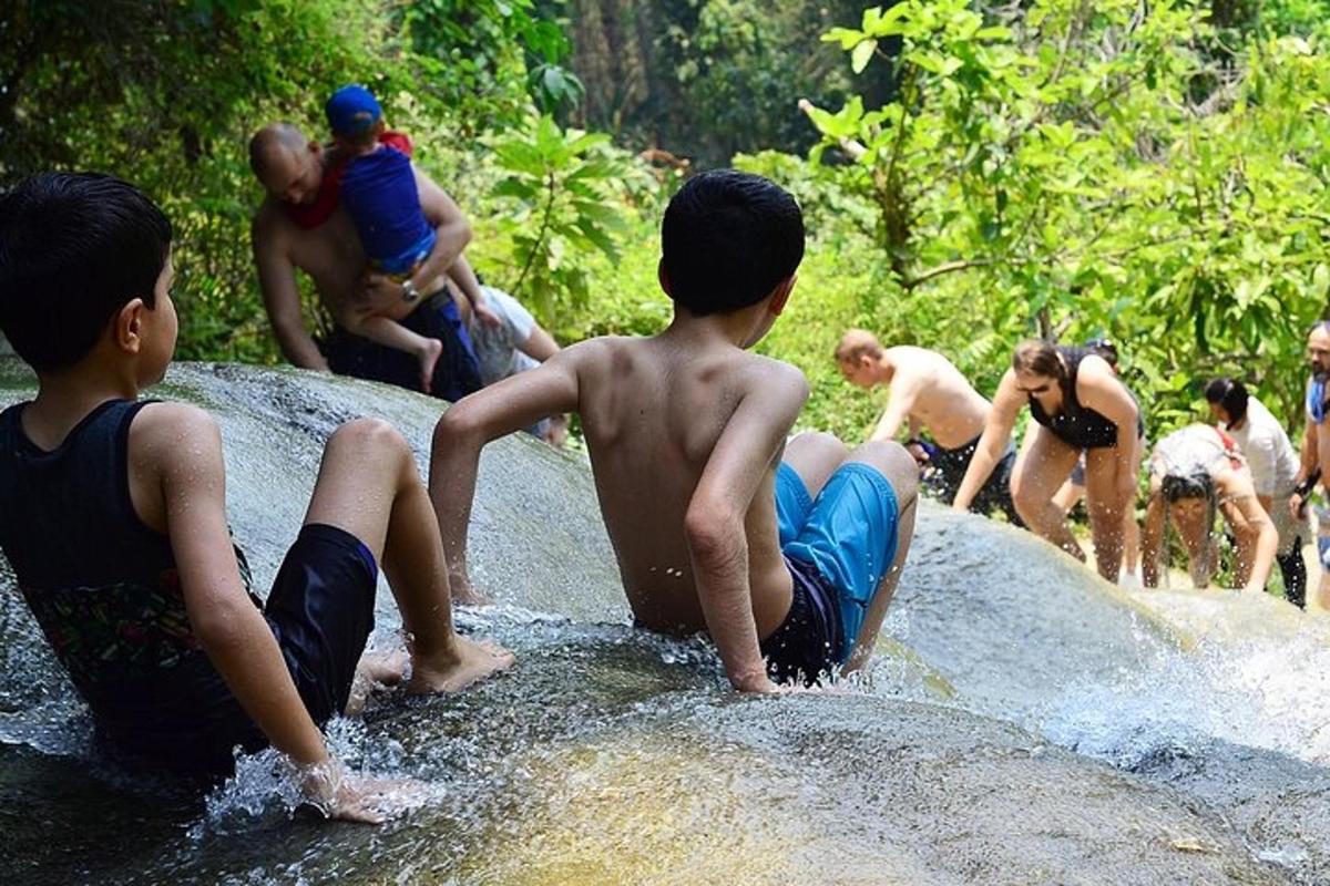 um grupo de meninos sentados em pedras na água